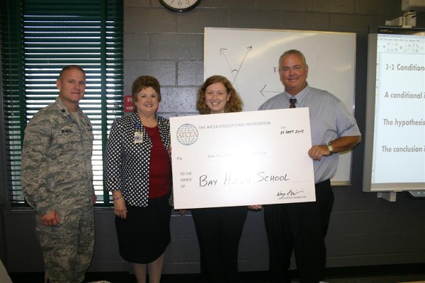 In September, Lt. Col. Wayne Wisneski, USAF (l), chapter president, presents a Science Teaching Tools grant to Morgan Sansbury (2nd from r) of Bay High School while Sandra Davis, assistant superintendent for Bay County schools, and Billy May, Bay High School principal, look on.